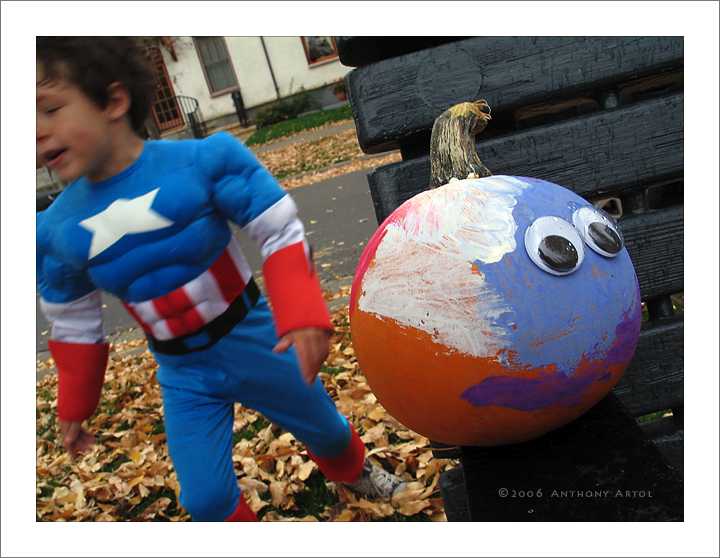 Boy in Superman's Costume and painted pumpkin